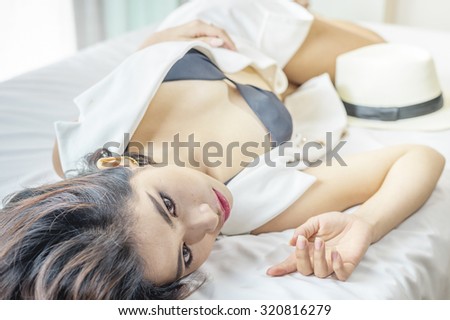 Sexy Asian woman black bikini lying on the bed