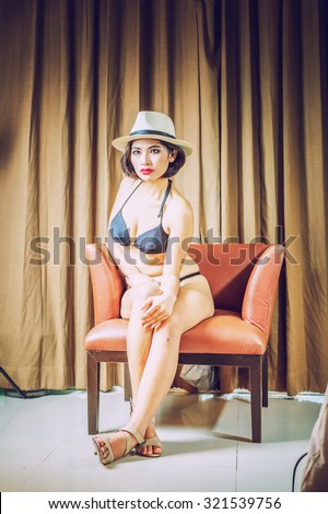 asia beautiful women in bikini sitting on chair at the room, vintage style