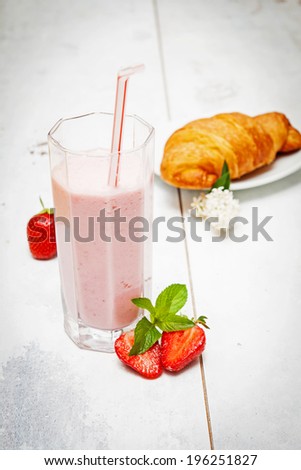Healthy breakfast consisting of strawberry yogurt, fresh berries and croissant