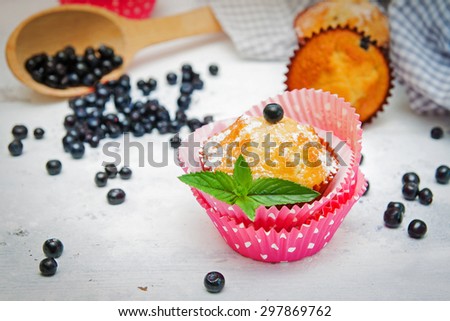 Blueberry muffins on white wooden table against ingredients from the receipt