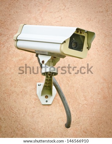 CCTV security camera on brown wall  in the city