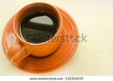 Cup of black coffee  on wooden table with text area.