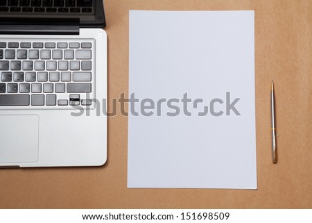 blank paper and laptop on table