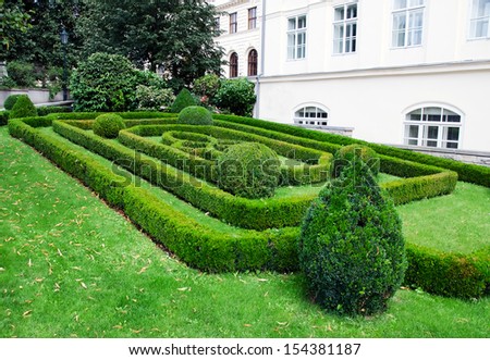 Facade of a building with a beautiful garden in front of it.