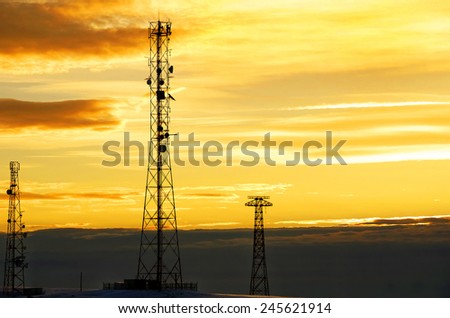 Silhouette view of cellphone antenna under twilight sky.