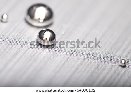 Shiny Mercury drops on a textured surface
