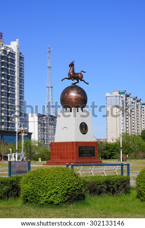 China town of Heihe cityscape, Wansu street. Decorative monument with galloping horse against blue sky background. Heilongjiang province, China. May 31, 2015.