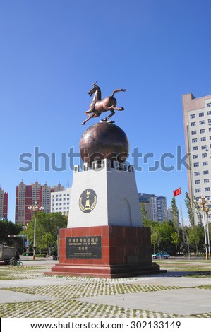 China town of Heihe cityscape, Wansu street. Decorative monument with galloping horse against blue sky background. Heilongjiang province, China. May 31, 2015.