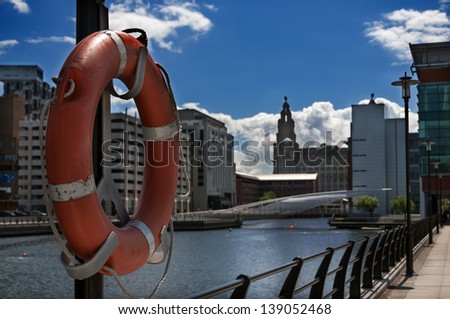 Life buoy in the foreground and buildings at liverpool dock in the background. Image no 144.