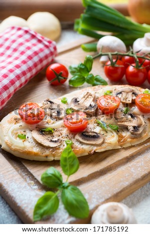 vegan mini pizza with mushrooms and tomatoes