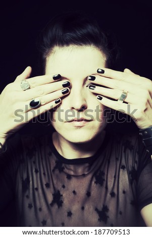 dark portrait of a woman with hands on eyes