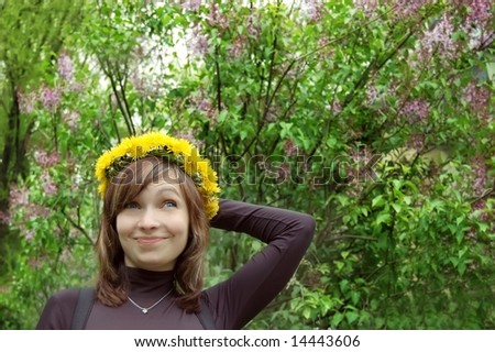 Surprised pretty girl with dandelion diadem ofer lilac background