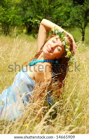 beautiful girl with flower diadem in fields