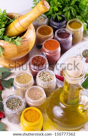 Mix of fresh herbs, spices and oil with mortar on the table