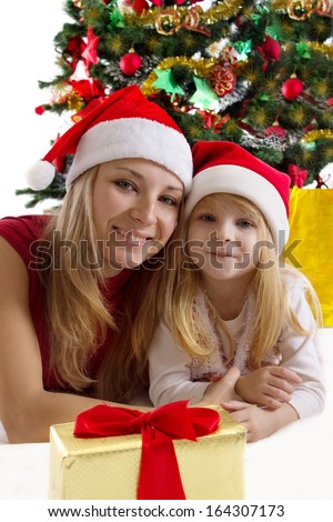 Mother and little daughter under Christmas tree