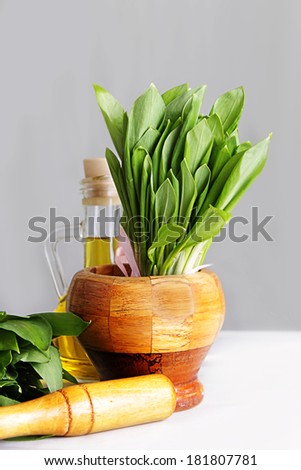 Cluster of fresh wild onion leaves in mortar and pestle