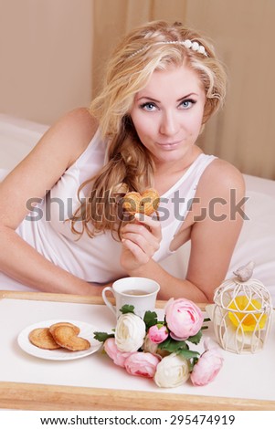 Sensual woman having breakfast in bed on tray
