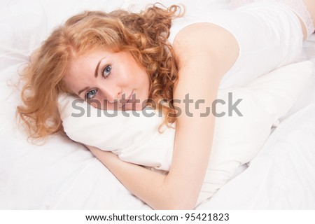 Red-headed woman in underwear on pillow relaxing