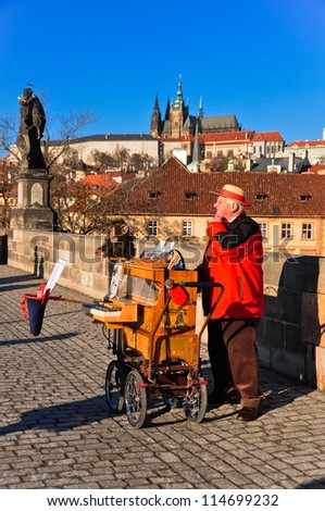 PRAGUE, CZECH REPUBLIC - NOVEMBER 26: An unidentified man offers music from hand operated music box in exchange for money. Taken on Charles Bridge in Prague, Czech Republic on November 26 2009.