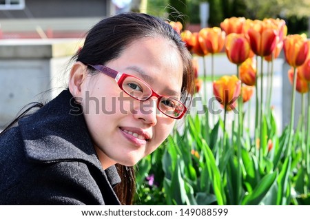 Beautiful Asian young woman outdoor portrait by the tulips