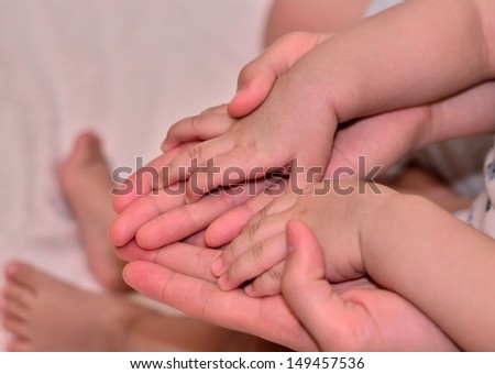Baby\'s hand on top of mommy\'s hand