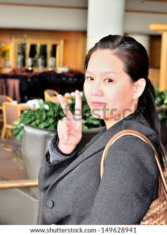 Asian woman pose victory hand sign