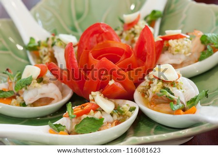 Shrimp in fish sauce Thai sea food with well decorated tomato in the middle of the plate which makes it look stunning. The dish was designed with spoons each hold one bite of shrimp