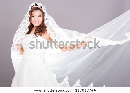 Bride dressing in white spins around happy with veil spread to the right