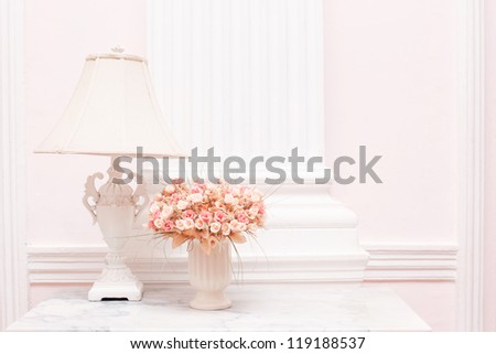 Vintage white lamp and flower vase on white desk against white background