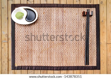 Japanese stick and cup of shoyu and wasabi on wooden table ready for meal