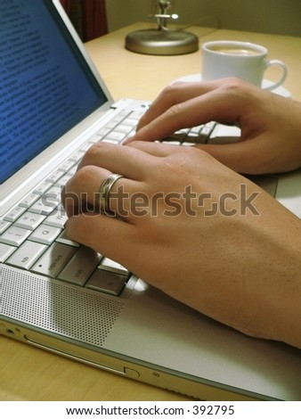 man\'s hands typing on laptop at desk