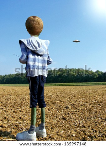 Alien boy flying a remote control flying saucer