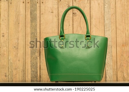 green purse on wood background, luxury women accessory