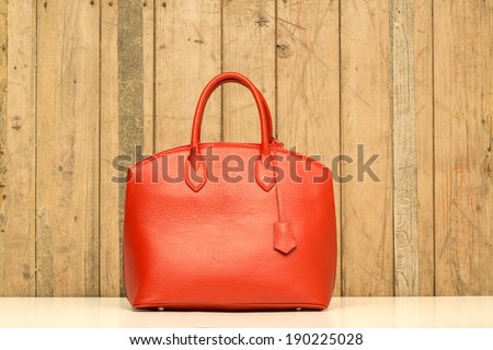 red purse on wood background, luxury women accessory