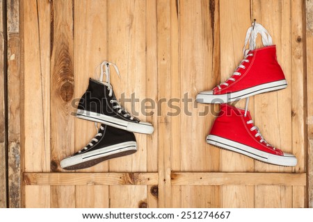 Vintage hanging shoes tied on wooden background