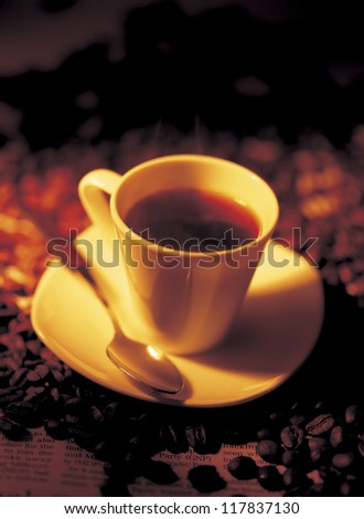 a cup of coffee placed on coffee beans