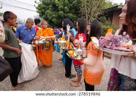 KANCHANABURI, THAILAND -  MAR 25, 2015: Unknown People, give food offerings to a Buddhist monk in Morning, Sangkhlaburi, Kanchanaburi Thailand. As the successor to a long tradition.