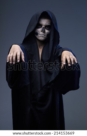 Teen with makeup skull cape stretched his arms forward