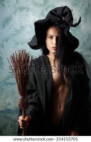 beautiful sexy girl in a witch costume with a broom