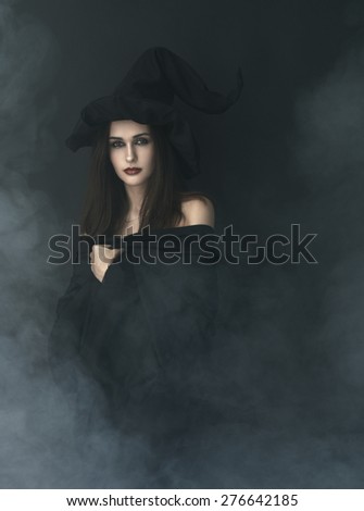 slender witch in a smoke on a black background