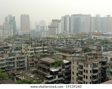 large housing complexes covered with plants surrounded by high rise building in downtown Guangzhou, China.