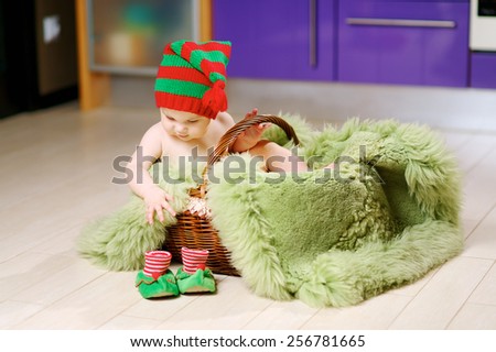 6 month baby photo shoot in a basket on a green fur in the red-green cap