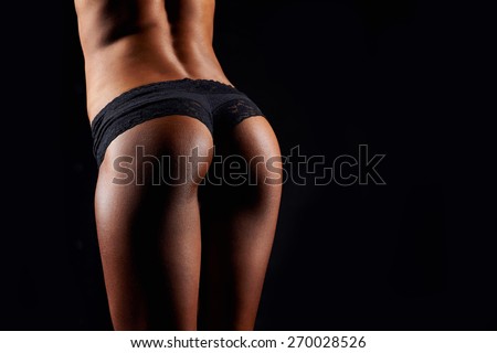 Beautiful tanned women\'s buttocks. Beautiful ass. Tanned fitness ass. Sporty sexy girl with buttocks in black sportswear. Tanned young sexy athletic girl. A great sport female body close up.