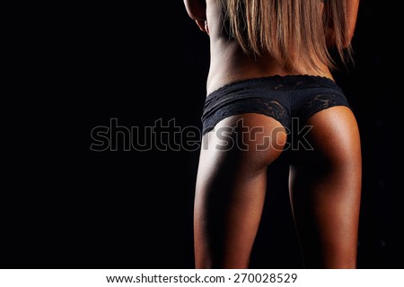 Beautiful tanned women\'s buttocks. Beautiful ass. Tanned fitness ass. Sporty sexy girl with buttocks in black sportswear. Tanned young sexy athletic girl. A great sport female body close up.