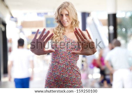 young woman stop gesture in a shopping center