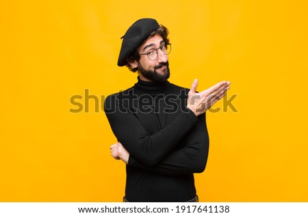 young french artist man feeling confused and clueless, wondering about a doubtful explanation or thought against orange wall Photo stock © 