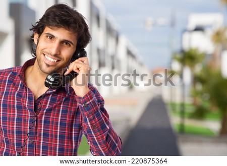 cool indian man speaking on telephone