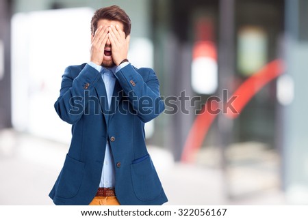 scared businessman covering eyes
