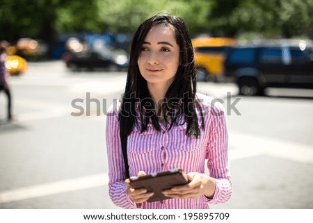 Young latina hispanic woman in New York City walking using tablet pc computer