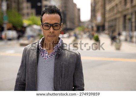 Young black African Asian man in city serious face portrait